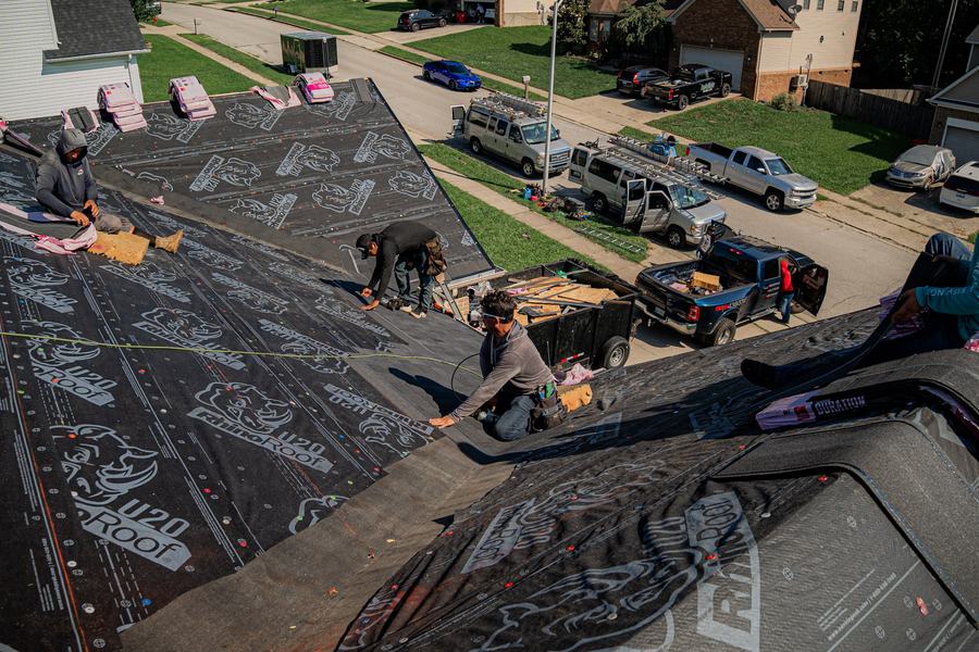 Next Level crew installing new underlayment on a roof replacement